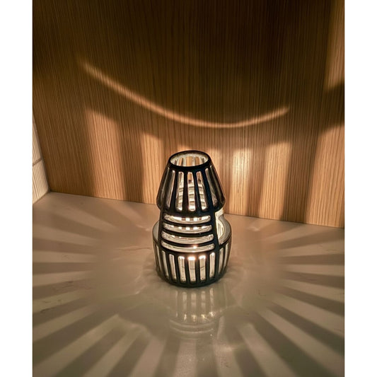 Decorative lantern on a reflective surface with wooden wall background