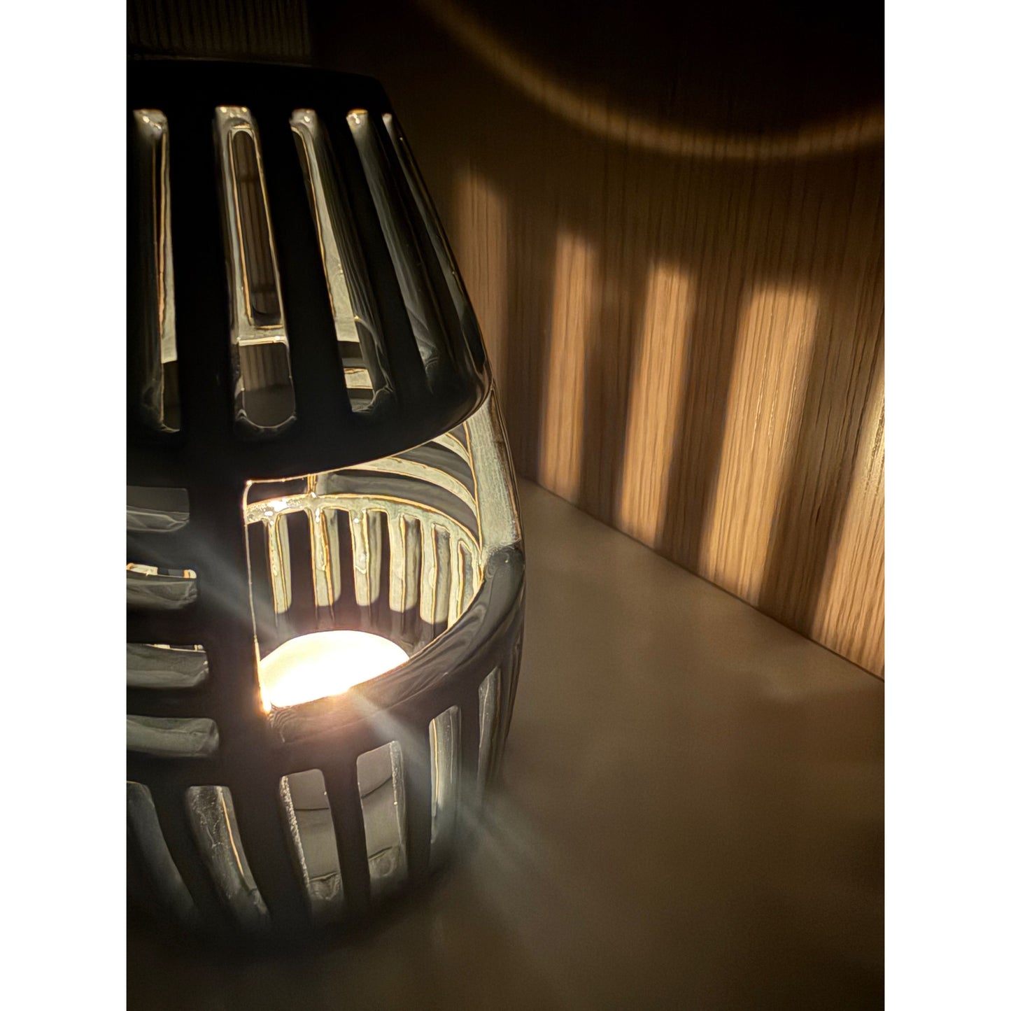 Decorative lantern with a warm glow on a wooden surface