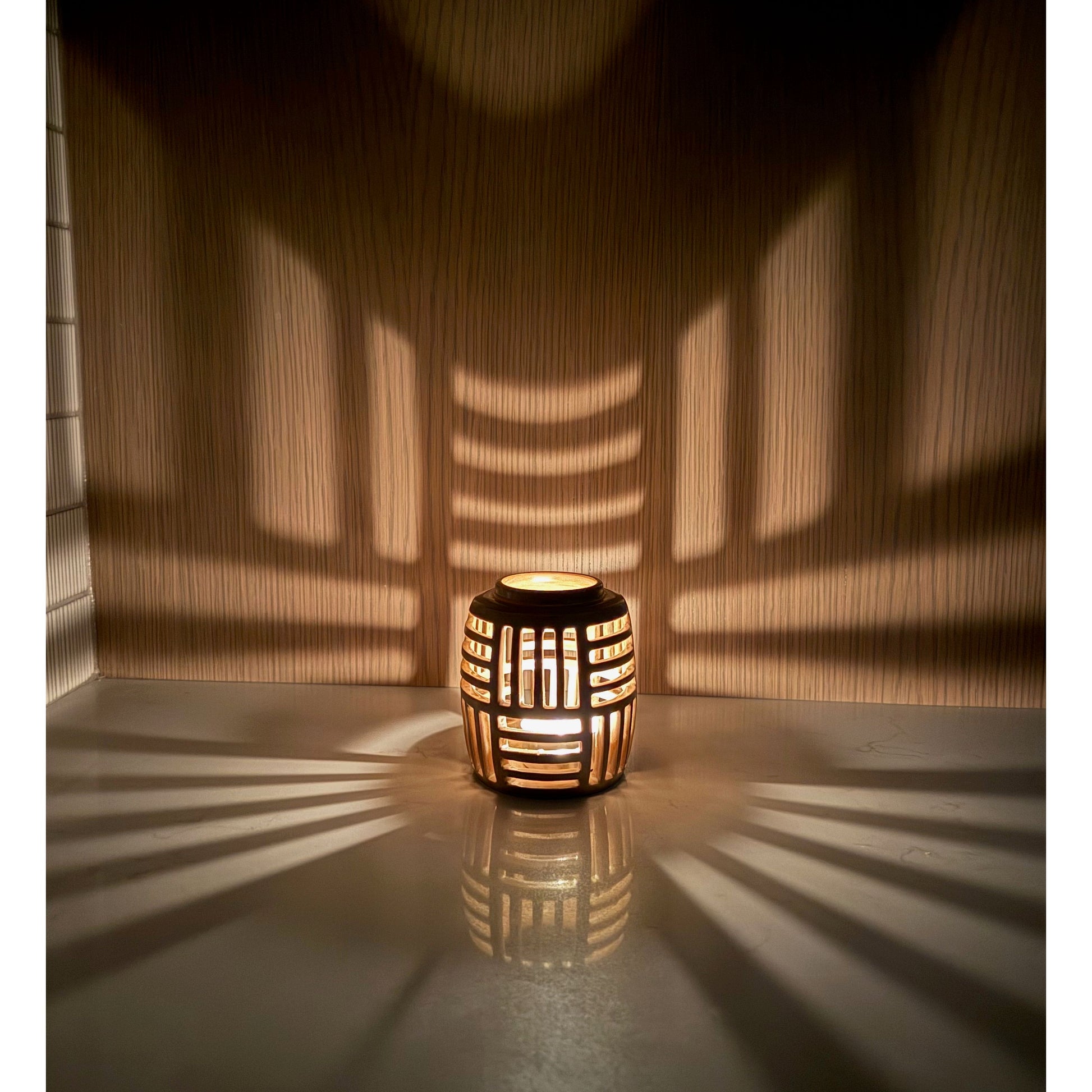 Decorative lantern casting shadows on a wooden wall